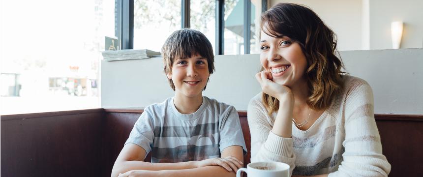 Woman and son sitting in a coffee house together.